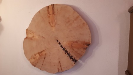 Zirbenstammscheibe mit Lederband als Wanddeko.